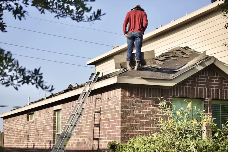 Professional roofer working on a residential roof in Roann